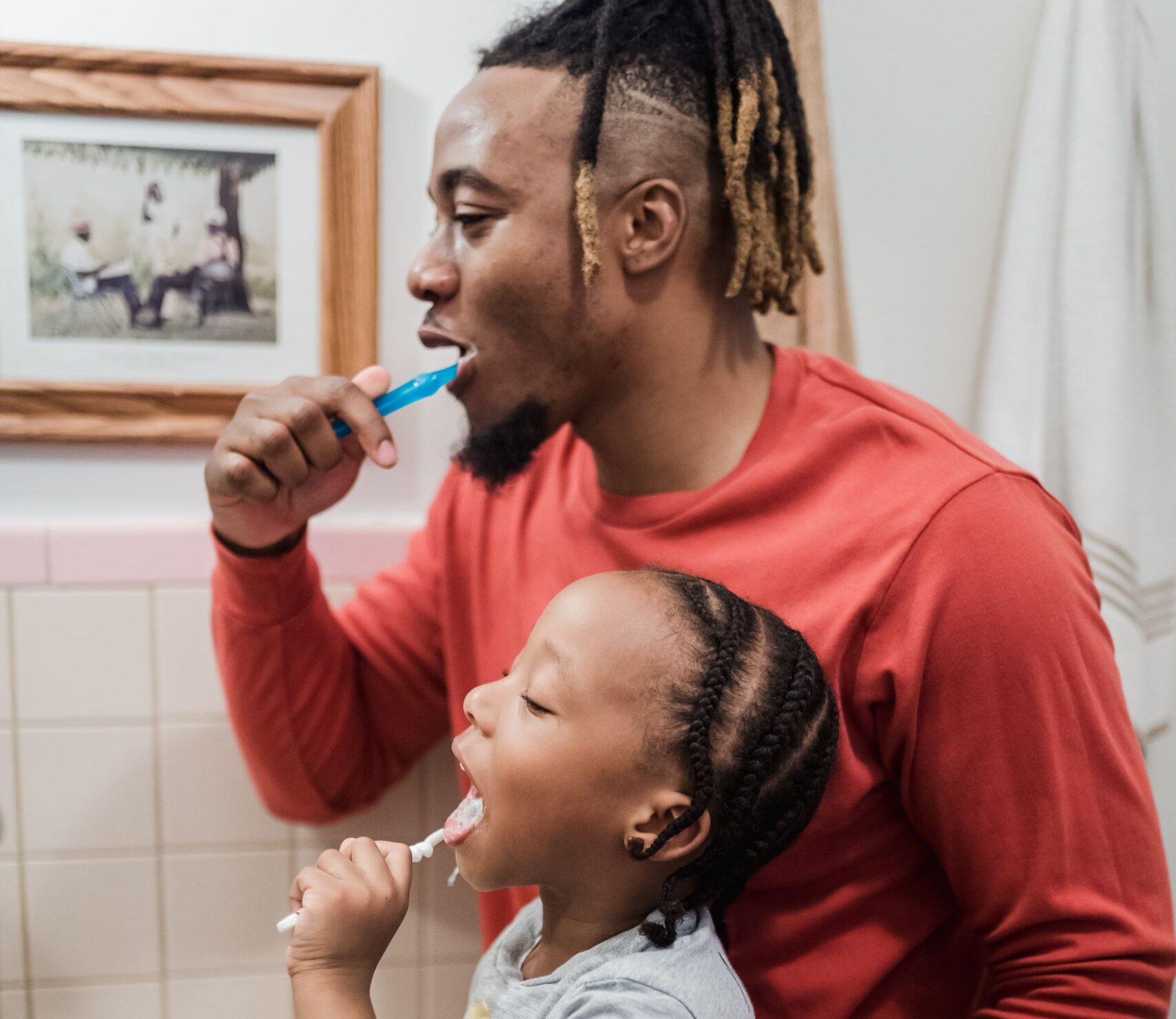 Father and daughter sharing a morning routine in the bathroom, promoting hygiene and togetherness.